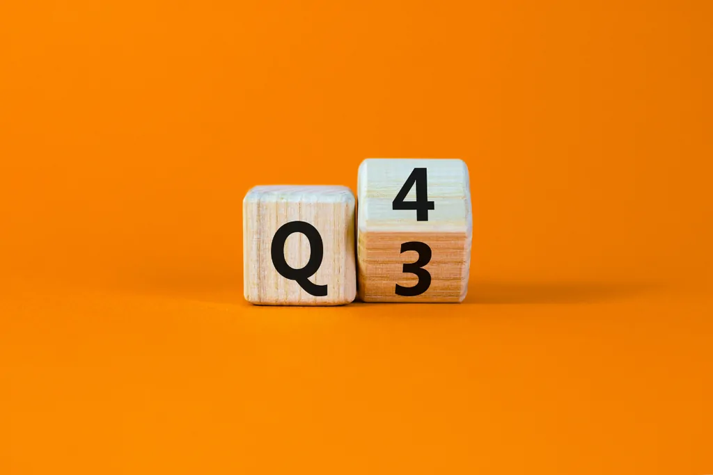 Wooden blocks turning from Q3 to Q4 against an orange background